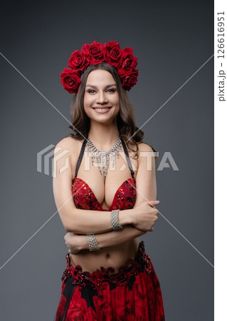 Woman in red outfit with floral headpiece poses confidently for the camera Woman in red outfit with floral headpiece poses confidently for the camera 126616951