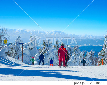 快晴の樹氷原と眺望を楽しむ滑走者達 (山形県、蔵王温泉スキー場、樹氷原コース) 126618469