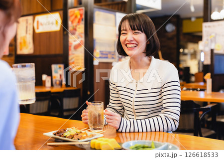 居酒屋でお酒を飲みながら談笑する女性 居酒屋でお酒を飲みながら談笑する女性 126618533