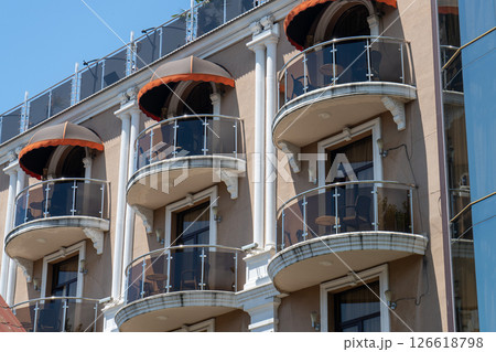 Facade of a multi story building with mirrored windows and balconies. Facade of a multi story building with mirrored windows and balconies. 126618798