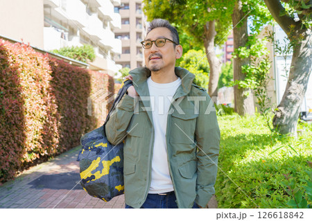 住宅街を歩くミドルエイジの男性のポートレート 126618842