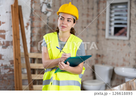 Female architect checking project documentation Female architect checking project documentation 126618893