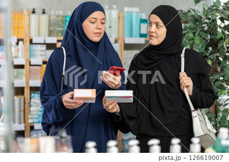 Two Muslim women scanning QR-code on pills box Two Muslim women scanning QR-code on pills box 126619007
