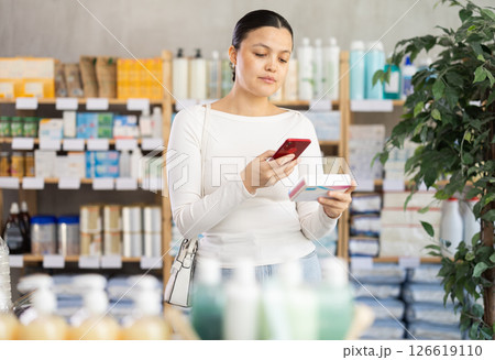 Asian woman scans qr code on pill pack Asian woman scans qr code on pill pack 126619110