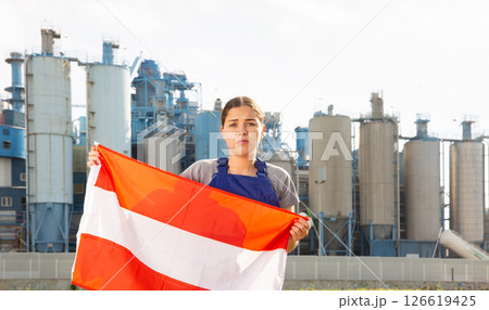 Sad young woman near factory with flag of Austria 126619425