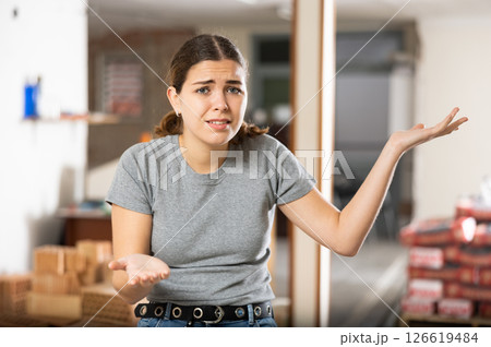Disappointed woman standing in construction site Disappointed woman standing in construction site 126619484