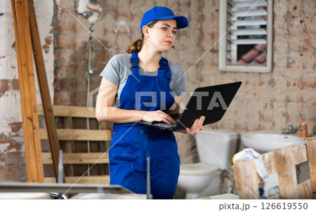 Woman with laptop on indoor construction site Woman with laptop on indoor construction site 126619550