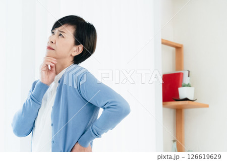 リビングで考え込む中高年女性 リビングで考え込む中高年女性 126619629
