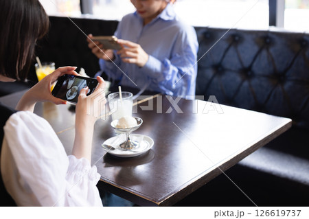カフェで注文したスイーツの写真を撮る女性 126619737