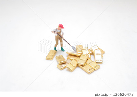 Worker with Gold Bars Depicting Wealth and Resource Concept Worker with Gold Bars Depicting Wealth and Resource Concept 126620478