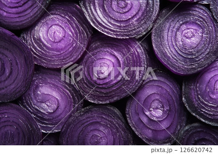 A close-up of fresh red onion slices arranged in a seamless pattern. The purple tones and detailed texture make it ideal for backgrounds, food packaging, food blogs or healthy eating campaigns. Banner 126620742