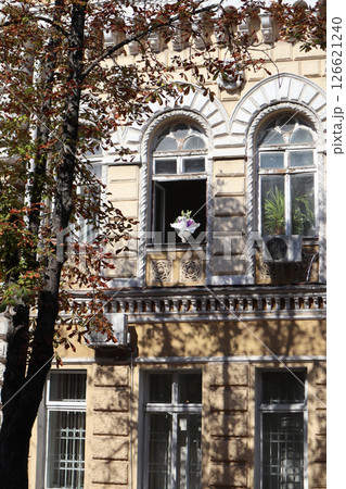 Bouquet of flowers at window of historic building. 126621240