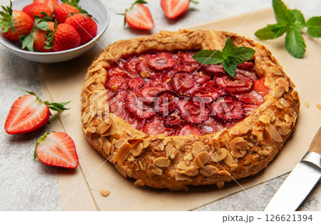 Delicious homemade strawberry galette with almond petals and fresh mint 126621394