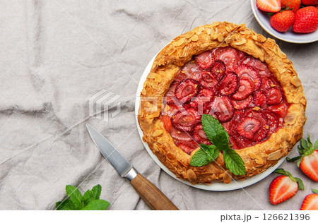 Delicious homemade strawberry galette decorated with almond petals and fresh mint Delicious homemade strawberry galette decorated with almond petals and fresh mint 126621396