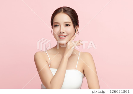A beautiful young Asian woman with clean, fresh skin against a pink background. Skincare, facial treatment, cosmetology, beauty, and spa. An elegant portrait of an Asian woman. 126621861