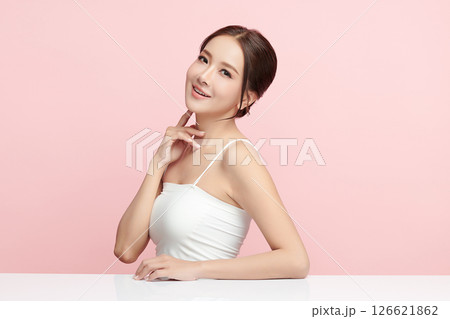 A beautiful young Asian woman with clean, fresh skin against a pink background. Skincare, facial treatment, cosmetology, beauty, and spa. An elegant portrait of an Asian woman. A beautiful young Asian woman with clean, fresh skin against a pink background. Skincare, facial treatment, cosmetology, beauty, and spa. An elegant portrait of an Asian woman. 126621862