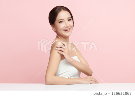 A beautiful young Asian woman with clean, fresh skin against a pink background. Skincare, facial treatment, cosmetology, beauty, and spa. An elegant portrait of an Asian woman. 126621865