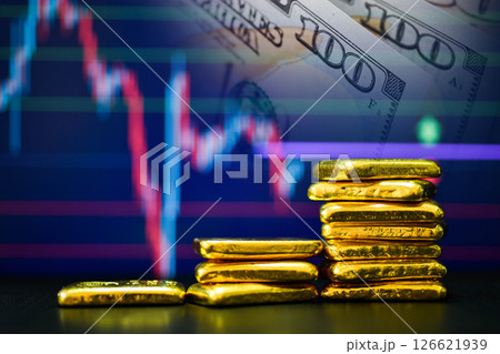 Photo a gold bars the candlestick chart and US dollar background , Fluctuations in gold prices concept. 126621939