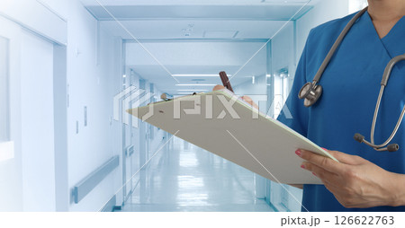 Female doctor write somthing while standing on the way of hospital corridor. 126622763