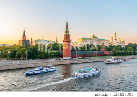View of Kremlin with Vodovzvodnaya tower, Grand Kremlin Palace from repaired Bolshoy Kamenny Bridge in Moscow city on sunny summer day. Cruise ship sails on the Moscow river 126623305