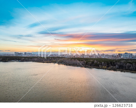 Colorful autumn forest with trees on the shore of a blue lake - top aerial view. Colorful autumn forest with trees on the shore of a blue lake - top aerial view. 126623718