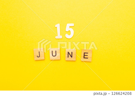 Top view of word 15 June calendar date made by wooden cubes on yellow color background Top view of word 15 June calendar date made by wooden cubes on yellow color background 126624208