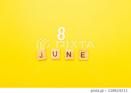 Top view of word 8 June calendar date made by wooden cubes on yellow color background Top view of word 8 June calendar date made by wooden cubes on yellow color background 126624211