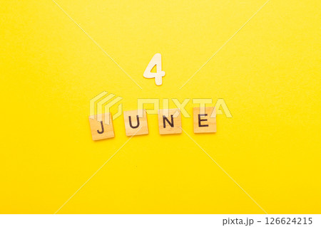 Top view of word 4 June calendar date made by wooden cubes on yellow color background 126624215