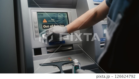 Cleaner Wiping Vandalized ATM Screen with Rag, Removing Graffiti 126624792