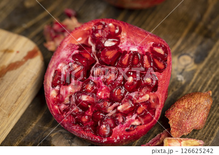 sliced red pomegranate on a table, sweet red pomegranate cut into pieces during cooking sliced red pomegranate on a table, sweet red pomegranate cut into pieces during cooking 126625242