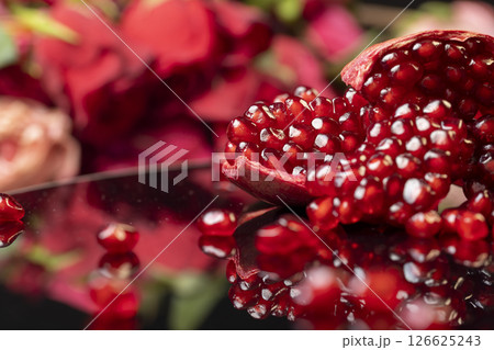 peeled ripe red pomegranate with juicy grains, side view peeled ripe red pomegranate with juicy grains, side view 126625243
