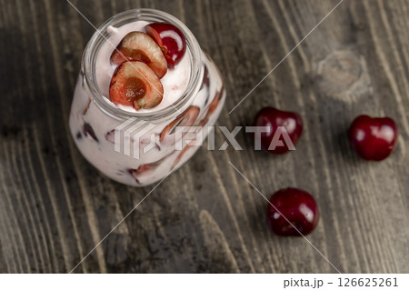 yogurt with cherry , jar with cherry yogurt with fresh red cherries close up, view from above 126625261