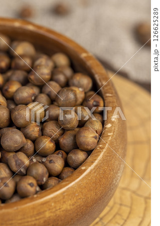 fried but not boiled chickpeas are on the table with a linen tablecloth, porridge is poured in a wooden bowl 126625289