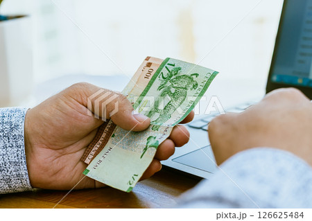 Close up of a man's hand counting money Omani money Close up of a man's hand counting money Omani money 126625484