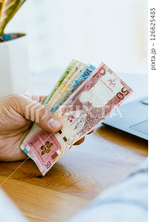 Close up of a man's hand counting money Qatar money Close up of a man's hand counting money Qatar money 126625485