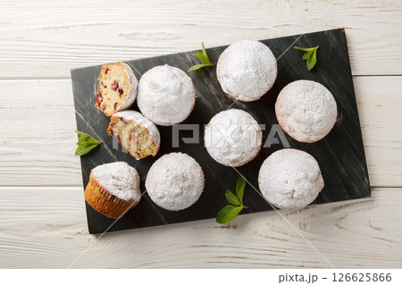 Stollen traditional Christmas German muffins with powdered sugar, raisins, candied fruits closeup on the board. Horizontal top view 126625866