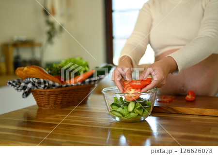 Pregnant woman preparing a healthy salad in a bright kitchen 126626078