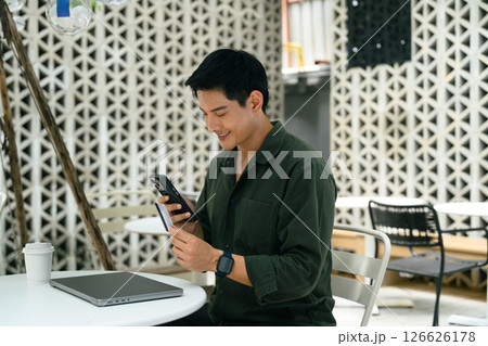 Adult asian man using mobile phone and credit card to complete a transaction 126626178