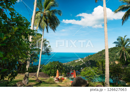 Tropical Paradise: Palm Trees, Breeze, and Azure Sea,vibrant view of a tropical island, seen through the shade of tall, majestic palm trees looking out towards the endless azure sea Tropical Paradise: Palm Trees, Breeze, and Azure Sea,vibrant view of a tropical island, seen through the shade of tall, majestic palm trees looking out towards the endless azure sea 126627063