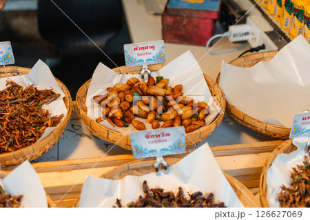 Fried Insects,Fried silkworms and other insect varieties are attractively arranged in woven baskets or various containers 126627069