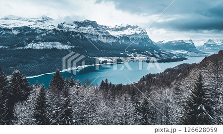 Majestic winter landscape featuring a serene lake surrounded by snow-covered mountains in Switzerland 126628059