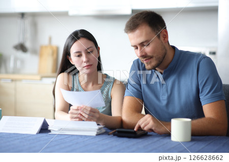 Interracial couple calculating expenses reading bill 126628662