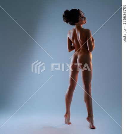 Captivating dance pose highlighting light and shadow with a nude figure 126628709