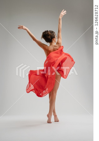 Captivating dance performance by a nude woman with flowing red fabric 126628712