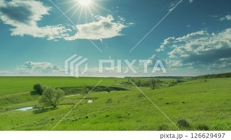 A Beautiful Lush Green Landscape Illuminated by Bright and Warm Sunlight, Captivating All Time lapse. A Beautiful Lush Green Landscape Illuminated by Bright and Warm Sunlight, Captivating All Time lapse. 126629497