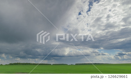 Stunning Dynamic Cloud Patterns Gracefully Drift Over Lush Green Agricultural Fields Time lapse. Stunning Dynamic Cloud Patterns Gracefully Drift Over Lush Green Agricultural Fields Time lapse. 126629661