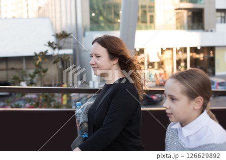 Mature woman and young girl child walking along the streets of the city 126629892