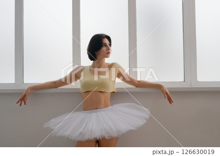 Woman practicing ballet in lingerie with a tutu in a dance studio Woman practicing ballet in lingerie with a tutu in a dance studio 126630019