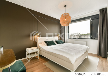 Stylish modern bedroom featuring neutral tones, cozy textiles, and contemporary lighting that creates a serene atmosphere for relaxation. Stylish modern bedroom featuring neutral tones, cozy textiles, and contemporary lighting that creates a serene atmosphere for relaxation. 126630460