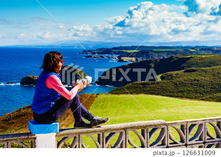 Tourist with camera on Asturias coast, Spain Tourist with camera on Asturias coast, Spain 126631009